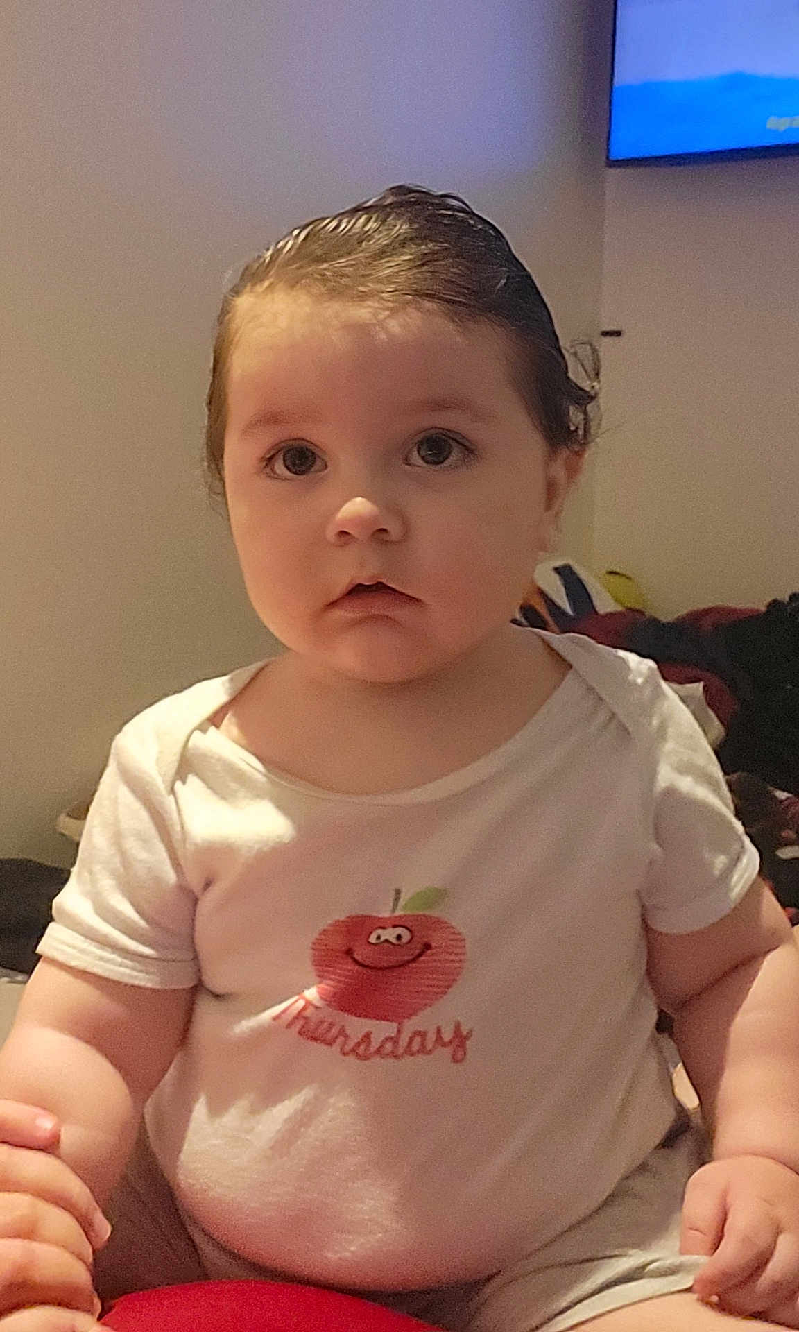 Laurentiu Mihail a rejoint le concours — aidez-le/la à gagner de superbes lots ! toddler, child, baby, indoor, white_tshirt, apple_graphic, curly_hair, sitting, cute, face, portrait, young_child, expression, casual_clothing, room, background, skin, hand, person, eyes