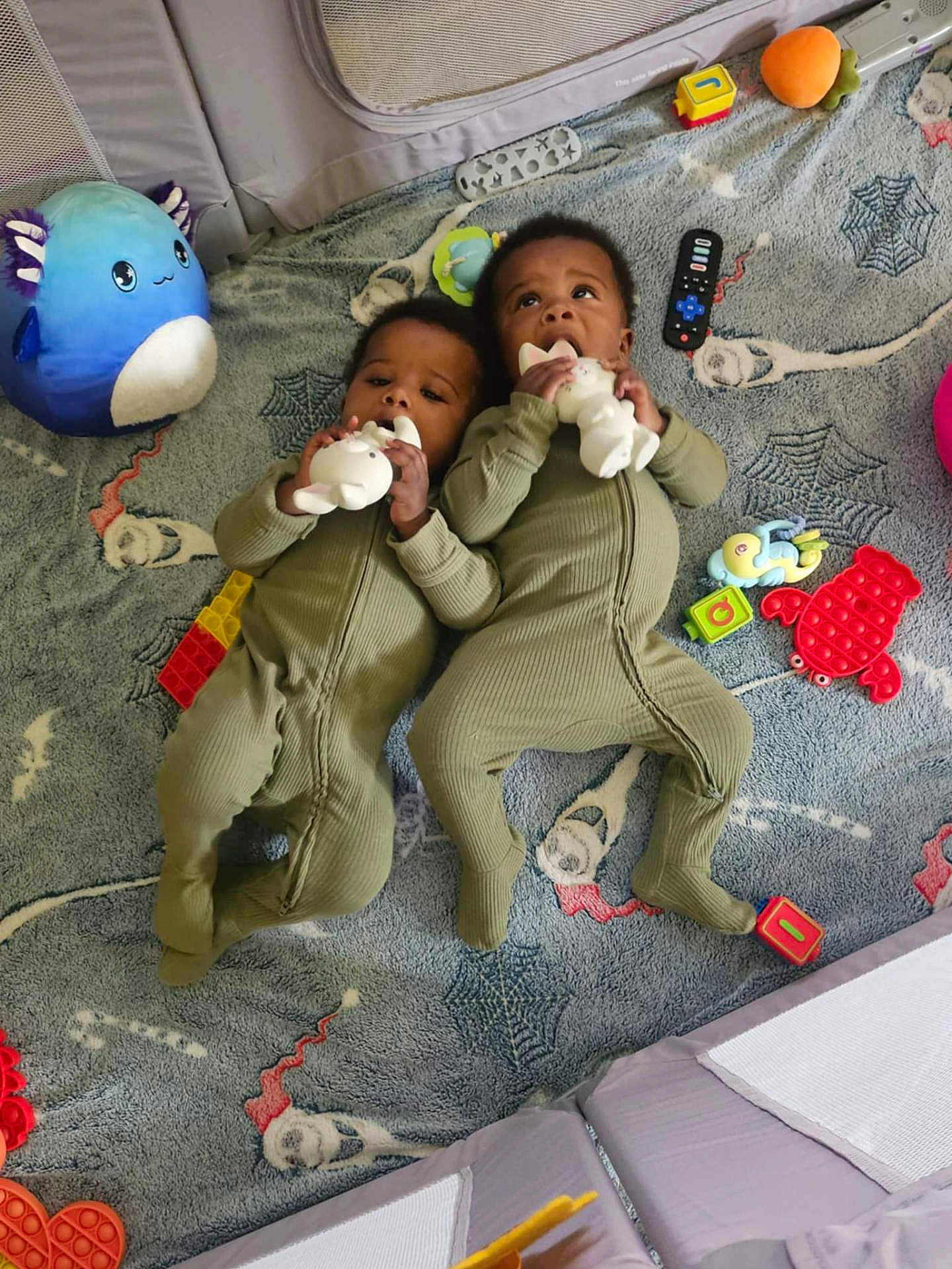 Kai'Ir And Kaidin joined the competition — help win amazing prizes! twins, baby, infant, onesie, toy, plush_toy, pop_it_toy, building_blocks, blanket, floor, child, playtime, cute, lying_down, indoor, patterned_blanket, colorful, chewing_toy, matching_outfits, happy