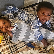 Kai'Ir And Kaidin is registered to the contest to win money with this photo: baby, babies, blanket, plaid, toy, carrot, pajamas, playpen, infant, cute, child, sleepwear, toddler, indoors, lying_down, sibling, face, hand, footwear, expression