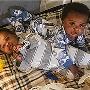 Kai'Ir And Kaidin is registered to the contest to win money with this photo: baby, babies, child, infant, playpen, blanket, pajamas, toy, plaid, indoor, cute, sleepwear, lying_down, face, expression, soft_lighting, comfort, childhood, adorable, young
