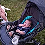 Abel is registered to the contest to win money with this photo: baby, stroller, grass, outdoor, child, bottle, person, dog, clothing, footwear, legs, seatbelt, summer, happy, infant, baby_boy, polka_dot, shorts, casual, playful