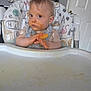 Martin is registered to the contest to win money with this photo: toddler, high_chair, messy_face, snack, bib, food, indoor, child, expression, curious, hair, face, hands, tray, door, painting, furniture, clothing, person, home