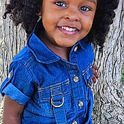 Noemie joined the competition — help win amazing prizes! child, girl, toddler, portrait, smiling, happy, outdoor, tree, denim, jumpsuit, curly_hair, hair_bows, blue_clothing, standing, facing_camera, brown_skin, nature, daylight, closeup, photograph