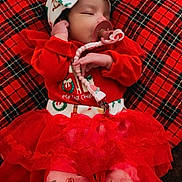 Feliciana joined the competition — help win amazing prizes! baby, infant, sleeping, red_clothing, tutu, pacifier, headband, bow, plaid_blanket, holiday_theme, christmas, decorations, snowflake_pattern, cute, cozy, indoors, soft_lighting, toddler, festive, blanket