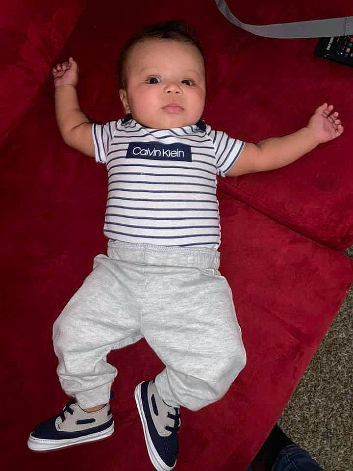 Khari joined the competition — help win amazing prizes! baby, baby_toddler_clothing, cheek, cool, eye, face, facial_expression, flash_photography, fun, gesture, happy, head, human, joint, person, product, red, sleeve, standing, t_shirt