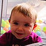 baby, child, smiling, face, eyes, teeth, hair, purple_clothing, playpen, ball_pit, colorful_balls, indoor, infant, cute, happy, portrait, closeup, soft_surface, fun, play