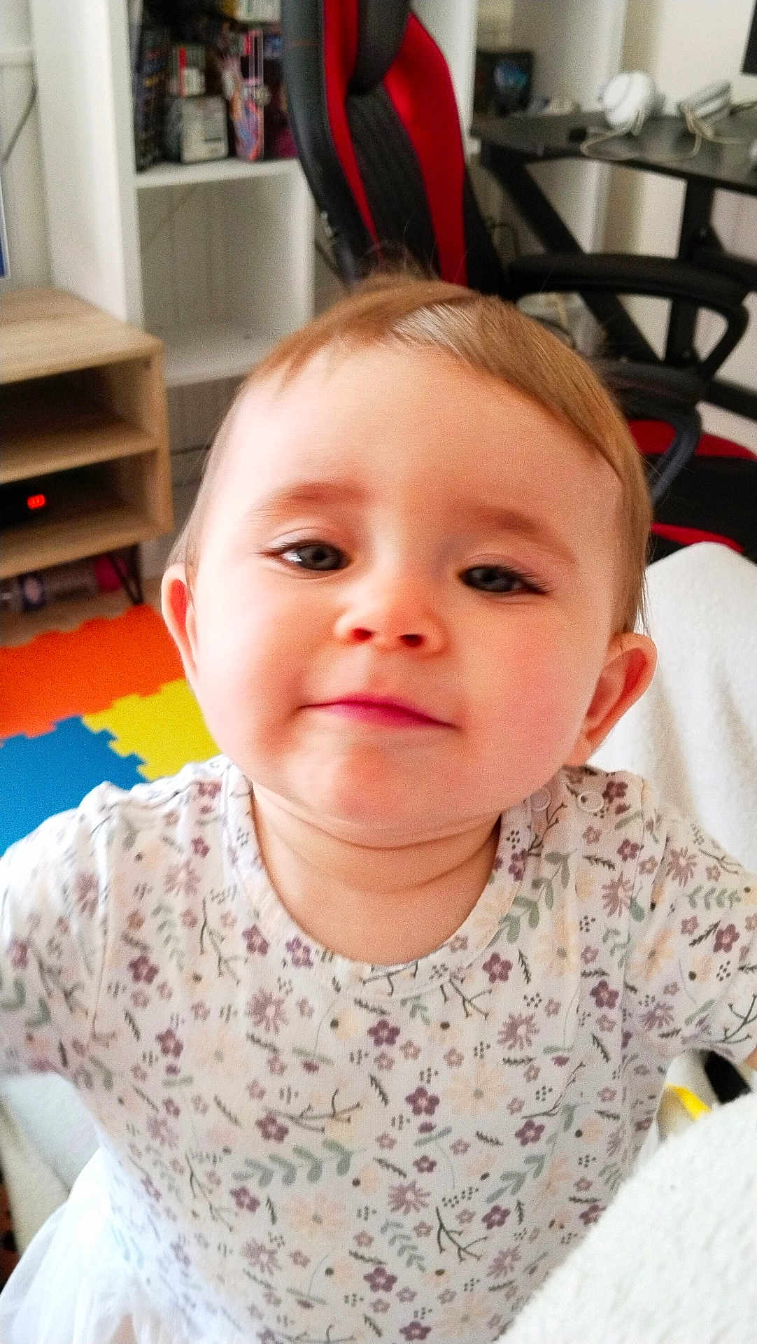 Elena participe au concours pour gagner de l'argent avec cette photo : toddler, child, face, portrait, indoor, floral_shirt, curious, smile, baby, furniture, chair, colorful_mat, gaming_chair, person, young_child, head, expression, home, cute, clothing