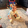 baby, carpet, child, clothing, couch, dresser, furniture, happy, home, indoor, learning_toy, living_room, playtime, portrait, rug, shoes, sitting, smiling, toddler, toy