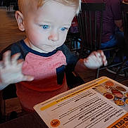 Branson joined the competition — help win amazing prizes! child, toddler, blue_eyes, blond_hair, menu, restaurant, table, chair, indoor, person, clothing, pink_shirt, curious, hands, food, menu_text, wood_floor, people, glasses, seated