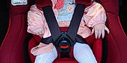 Thaïs participe au concours pour gagner de l'argent avec cette photo : baby, child, car_seat, red, pink, hooded_jacket, white_tights, leopard_print_shoes, bow, safety_harness, infant, cute, portrait, indoor, seatbelt, clothing, footwear, expression, person, car_interior