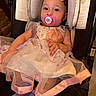 Amiya is registered to the contest to win money with this photo: baby, child, car_seat, pacifier, dress, purple_socks, hair_clip, indoor, cute, sitting, child_fashion, portrait, infant, comfort, safety, fabric, tulle, pink, purple, adorable