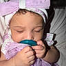 baby, infant, sleeping, pacifier, bow, headband, curly_hair, purple_cloth, cute, peaceful, hand, face, close_up, soft_light, child, adorable, portrait, indoors, sleep, toddler