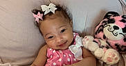 Amiya joined the competition — help win amazing prizes! baby, child, smile, pink_dress, bows, plush_toy, cushion, indoor, soft_fabric, cute, happy, portrait, infant, person, head, face, toy, relaxing, polka_dots, cozy