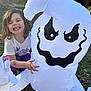 Sophia is registered to the contest to win money with this photo: child, girl, smile, happy, outdoor, grass, inflatable, ghost, halloween, toy, play, fun, sunlight, casual_clothing, tattoo, nature, expression, cute, holiday, seasonal