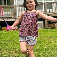 Sophia is registered to the contest to win money with this photo: child, girl, smiling, playful, outdoor, grass, tank_top, shorts, footwear, flip_flops, backyard, wooden_deck, toy, daylight, person, happy, posing, casual_clothing, nature, summer