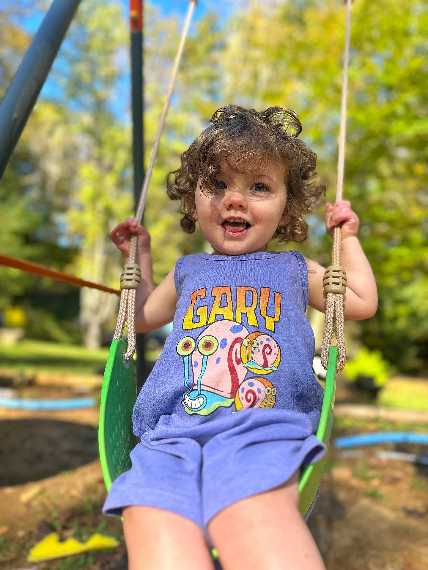 Addison joined the competition — help win amazing prizes! toddler, child, swing, outdoor, playground, curly_hair, purple_outfit, cartoon_snail, gary, smiling, sunlight, greenery, summer, happy, daylight, rope, fun, park, person, nature