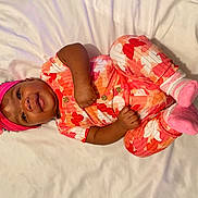 Kaiser joined the competition — help win amazing prizes! baby, infant, child, blanket, headband, flower, pink, orange, red, socks, clothing, lying_down, smiling, happy, cute, portrait, indoors, person, toddler, skin