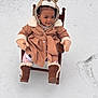Kaiser joined the competition — help win amazing prizes! toddler, child, snow, winter_clothing, coat, mittens, boots, chair, outdoor, hood, animal_theme, cute, cold_weather, footwear, pants, patterned_clothing, wooden_chair, smiling, sitting, curious