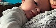 Amelia joined the competition — help win amazing prizes! baby, infant, adult, face, blanket, cozy, hug, closeup, indoor, person, sleepy, comfort, warm, soft, blue_wall, expression, cuddle, skin, clothing, portrait
