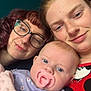 Amelia joined the competition — help win amazing prizes! baby, pacifier, adult, glasses, smile, indoor, portrait, closeup, person, face, redhead, curly_hair, blanket, floral_clothing, mickey_mouse, happy, family, skin, casual, head