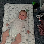 Amelia joined the competition — help win amazing prizes! baby, baby_clothes, baby_items, carpet, changing_pad, child, cloud_pattern, cute, diaper, floor, happy, indoor, infant, lying_down, nursery, onesie, pattern, person, smiling, white_clothing