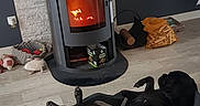 Orka a rejoint le concours — aidez-le/la à gagner de superbes lots ! dog, dogs, pet, black_dog, sleeping, lying_down, upside_down, relaxed, pet_bed, indoor, living_room, wood_stove, fire, warmth, cozy, wood_floor, home, furniture, animal, resting