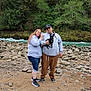 Koda joined the competition — help win amazing prizes! casual_clothing, couple, daytime, dog, forest, greenery, hoodie, nature, outdoor, people, pet, portrait, relaxed, river, rocks, scenic, smile, sneakers, trees, water