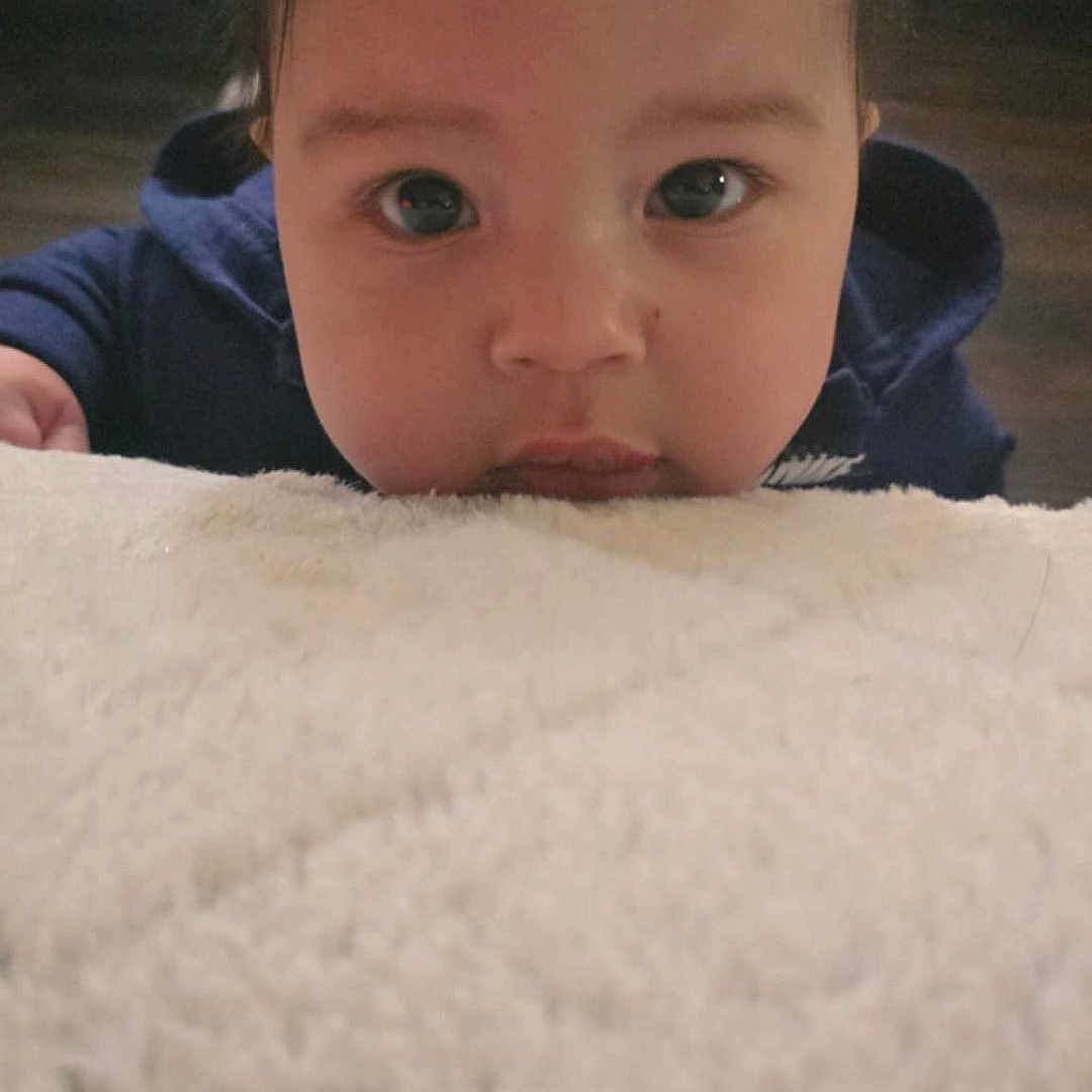 Xander is registered to the contest to win money with this photo: baby, bed, bedroom, blanket, clothing, coat, couch, cushion, face, furniture, head, homedecor, indoors, jacket, pants, person, photography, portrait, quilt, room