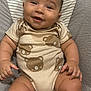 baby, child, smiling, onesie, bear_pattern, cushion, seat, chubby, cute, happy, infant, skin, face, hand, legs, indoors, toddler, clothing, portrait, person
