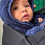 Leo is registered to the contest to win money with this photo: baby, child, face, hood, blue_hood, carrier, black_carrier, curious, wide_eyes, green_door, door, button, fabric, close_up, portrait, infant, warm_clothing, cute, snug, outdoor