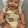 Leo is registered to the contest to win money with this photo: baby, smiling, infant, onesie, bear_pattern, cushion, seat, happy, child, cute, portrait, skin, chubby, sitting, indoors, comfortable, young, head, face, expression