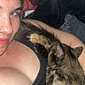 Pj is registered to the contest to win money with this photo: woman, cat, tortoiseshell_cat, freckles, black_tank_top, cuddling, indoor, close_up, pet, cute, relaxed, resting, face, hand, fur, comfort, bed, blanket, skin, casual