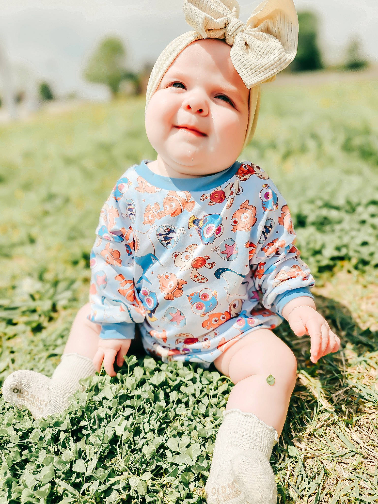 Serenity is registered to the contest to win money with this photo: baby, baby_toddler_clothing, beauty, cap, child, flash_photography, fun, grass, green, happy, joy, pattern, people_in_nature, person, photograph, sitting, skin, sleeve, smile, summer