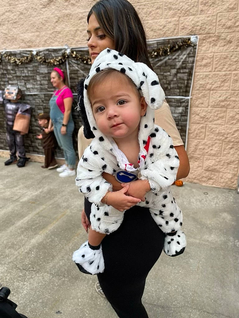 Adrian is registered to the contest to win money with this photo: bangs, blurred, child, costume, event, fashion_accessory, fur, hairstyle, happy, human_leg, joy, leg, leggings, pattern, person, recreation, shoe, sitting, sleeve, street