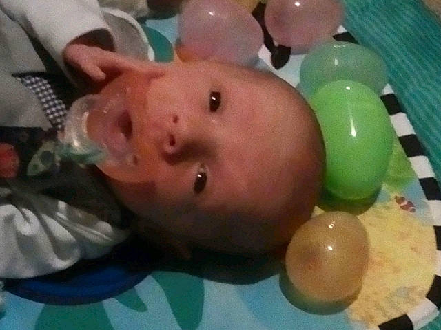 Bruce is registered to the contest to win money with this photo: abdomen, baby, baby_products, baby_toys, balloon, bathing, cheek, chest, child, ear, eyelash, fun, leisure, party_supply, person, plastic, play, table, thumb, toddler