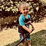 Jameson is registered to the contest to win money with this photo: child, boy, smiling, wet_hair, shorts, tshirt, barefoot, grass, garden, hose, outdoor, summer, play, happy, water, nature, greenery, daylight, person, fun