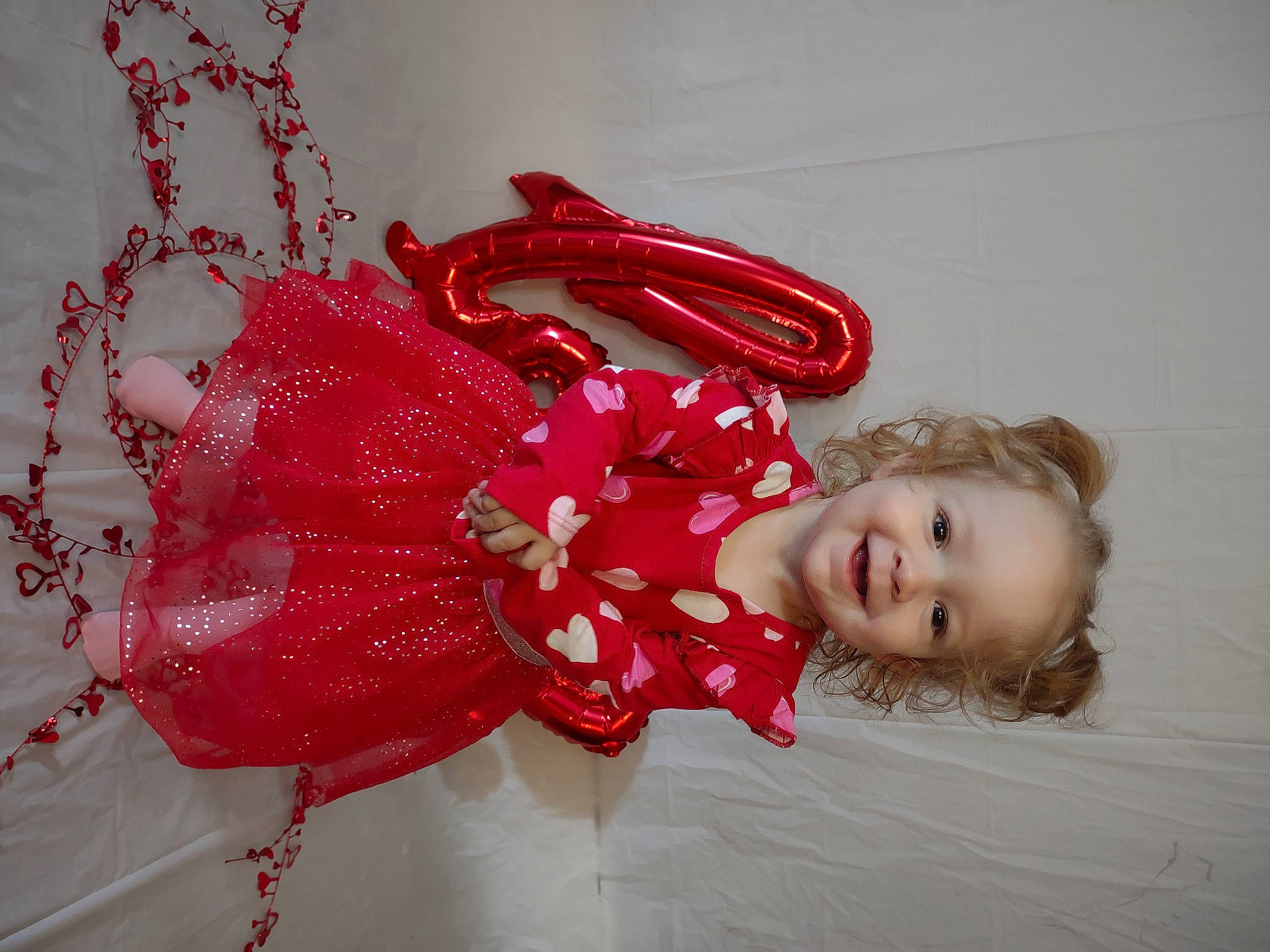 Jocelyn is registered to the contest to win money with this photo: baby_toddler_clothing, carmine, christmas, costume, embellishment, event, fashion_accessory, hair_accessory, happy, headband, headpiece, joy, magenta, material_property, pattern, person, pink, ribbon, sleeve, smile
