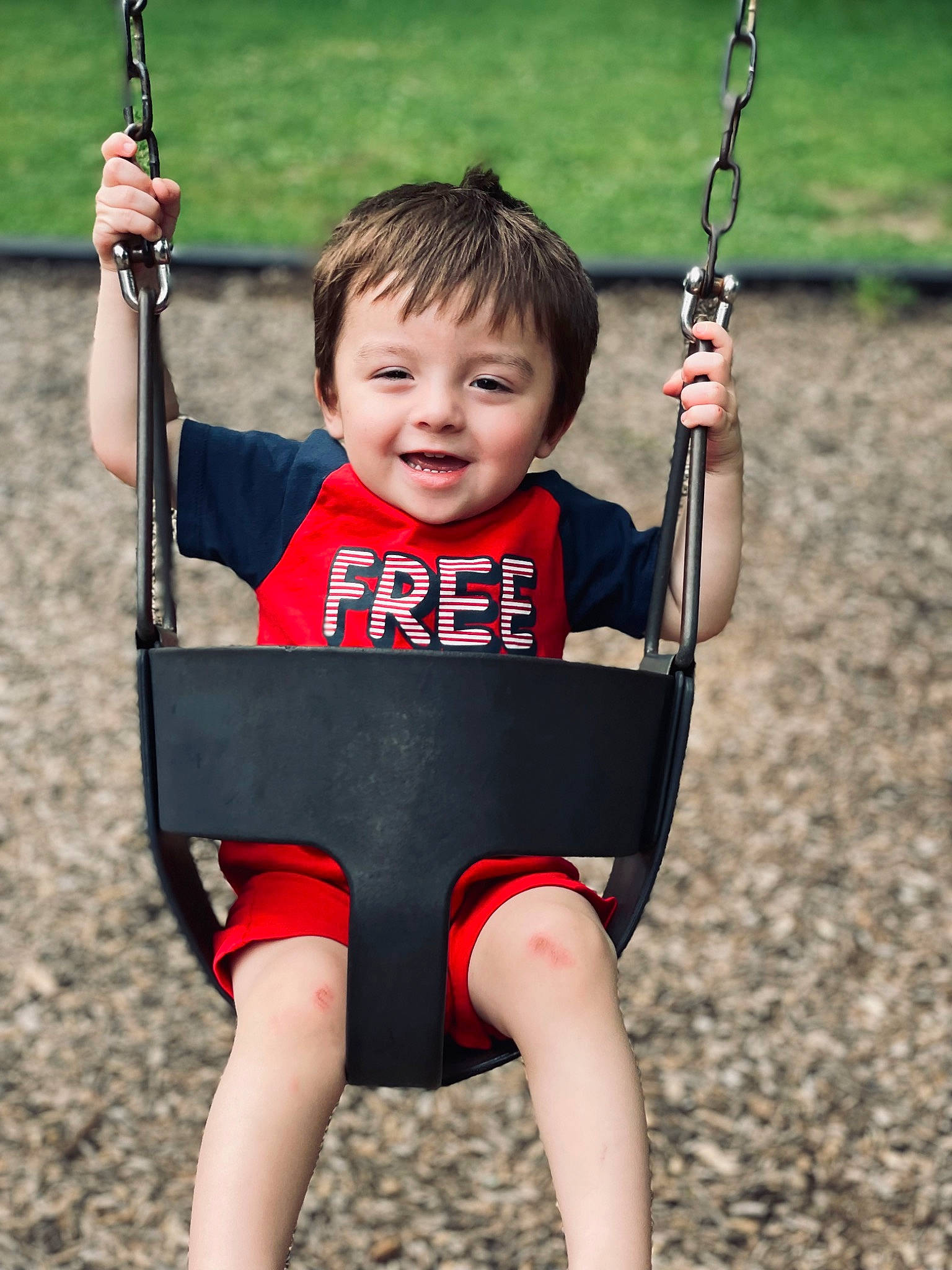 Amias joined the competition — help win amazing prizes! baby, black, face, grass, green, hand, happy, head, human_body, joy, person, photograph, playground, red, shoulder, skin, sleeve, smile, swing, toddler
