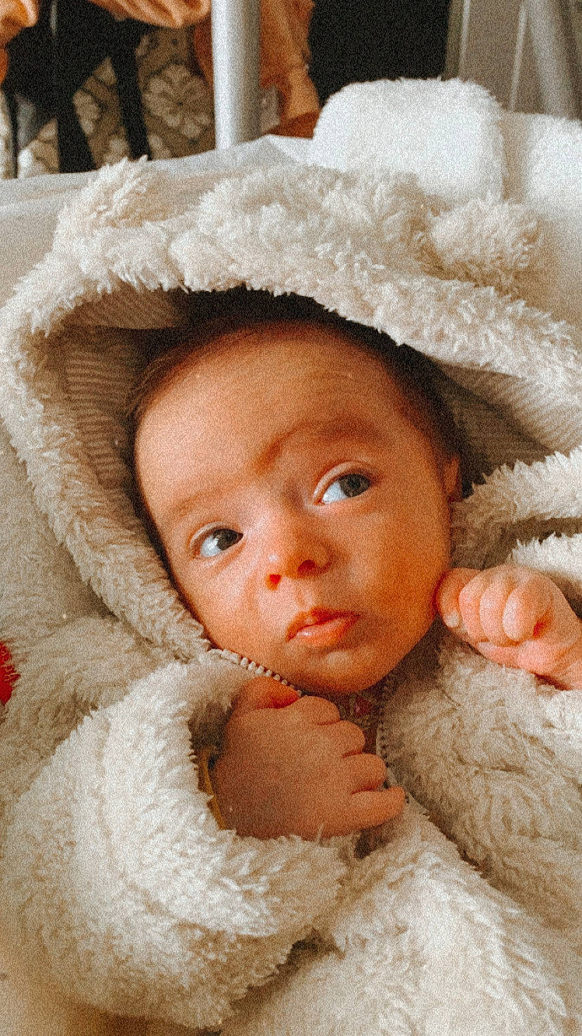 Della is registered to the contest to win money with this photo: baby, brown_hair, cheek, child, doll, eye, face, fur, head, headgear, linens, lip, nose, person, skin, textile, toddler, wool