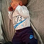 baby, infant, blanket, clothing, nike, person, side_view, newborn, cute, sleepwear, soft_texture, portrait, small_hands, laying_down, casual_wear, baby_clothes, indoors, cozy, resting, child