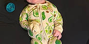 Alexander is registered to the contest to win money with this photo: 2026, avocado_pattern, baby, balloon, black_cushion, child, comfort, cushion, cute, expression, footed_pajamas, glasses, indoors, infant, novelty_glasses, pacifier, pajamas, sleepwear, smiling, yellow_background