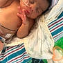 newborn, baby, infant, sleeping, blanket, nasal_tube, pacifier, medical, hospital, striped_blanket, patterned_blanket, cozy, cute, child, resting, indoors, person, soft, toddler, healthcare