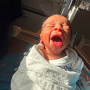 Royal is registered to the contest to win money with this photo: newborn, baby, yawning, wrapped, blanket, hospital, medical_equipment, crib, infant, child, person, indoors, soft_light, sleepy, cute, small, human, portrait, resting, newborn_baby