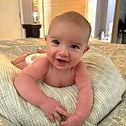 Jackson is registered to the contest to win money with this photo: baby, smiling, infant, pillow, blanket, indoor, child, face, happy, cute, skin, hands, bedroom, home, toddler, expression, portrait, person, lying, cozy