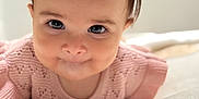Rosalynn is registered to the contest to win money with this photo: baby, child, face, pink_bow, knitted_sweater, close_up, curious_expression, soft_surface, indoor, portrait, cute, infant, young_child, skin, hair, eyes, head, person, smile, crawling
