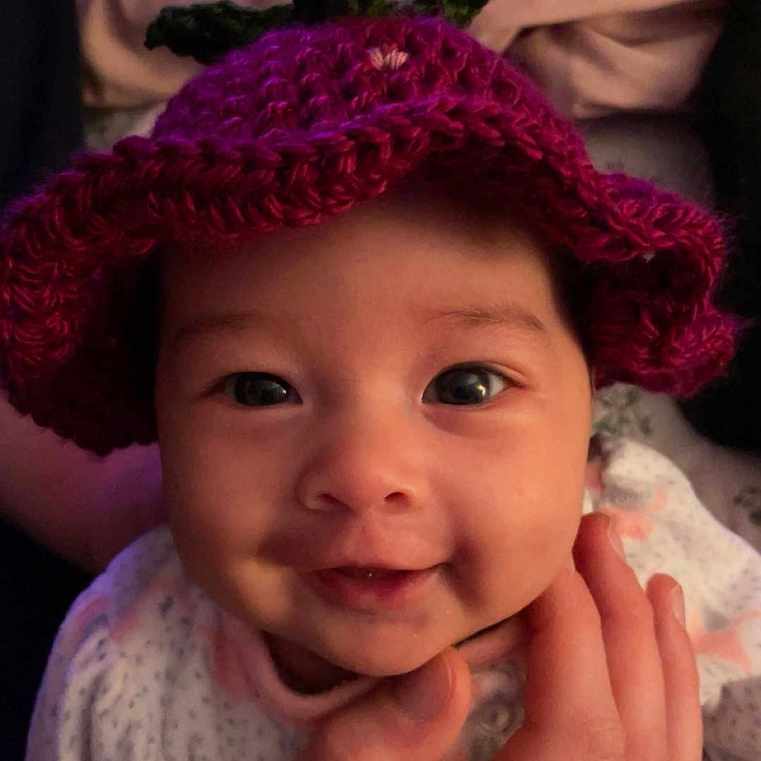 Silamay is registered to the contest to win money with this photo: baby, child, closeup, clothing, cozy, crochet, cute, expression, face, hand, hat, holding, indoor, infant, person, portrait, ring, smile, soft, warm