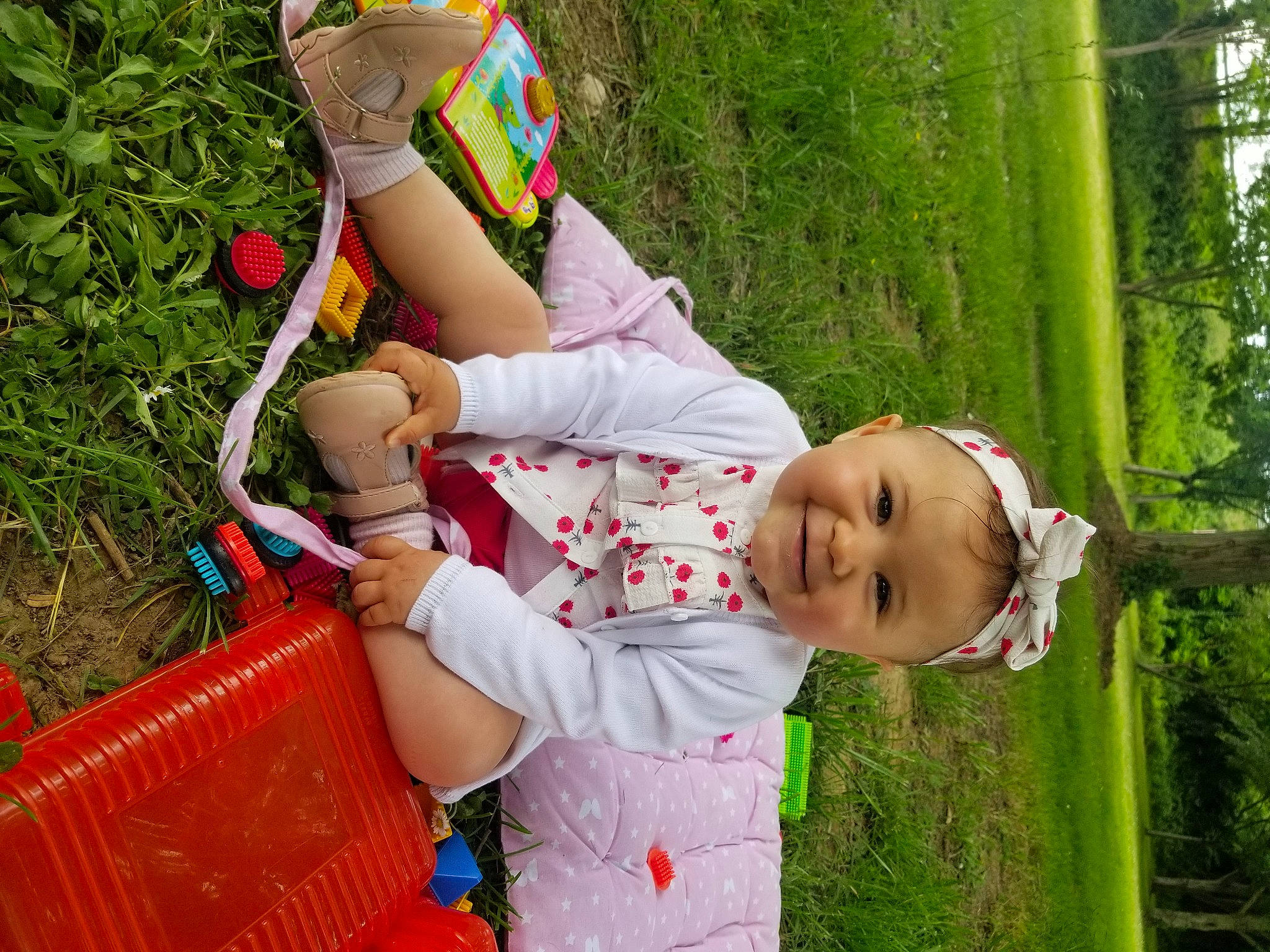 Ella a rejoint le concours — aidez-le/la à gagner de superbes lots ! baby, baby_toddler_clothing, child, clothing, fun, grass, green, happy, joy, leisure, people_in_nature, person, plant, play, recreation, sitting, soil, summer, tire, toddler