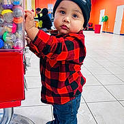 Austin M Sequeira L joined the competition — help win amazing prizes! toddler, child, beanie, red_jacket, checkered_clothing, gumball_machine, indoor, tile_floor, curious, standing, casual_clothing, shoes, playful, orange_wall, jeans, young_child, person, headwear, colorful, bright_lighting