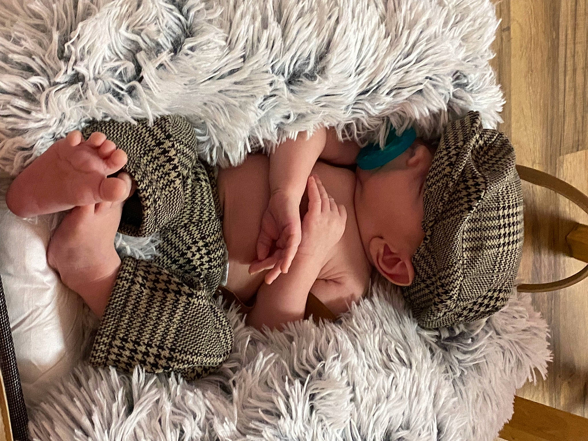 Cody is registered to the contest to win money with this photo: baby, baby_toddler_clothing, cap, comfort, dress, finger, flooring, foot, gesture, grass, happy, hat, human_body, leg, linens, person, textile, toddler, wood, wool