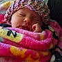 baby, newborn, infant, sleeping, blanket, knit_hat, hat, cozy, cute, closed_eyes, hand, portrait, indoors, bed, quilt, warm, soft_texture, pink, sleepy, adorable